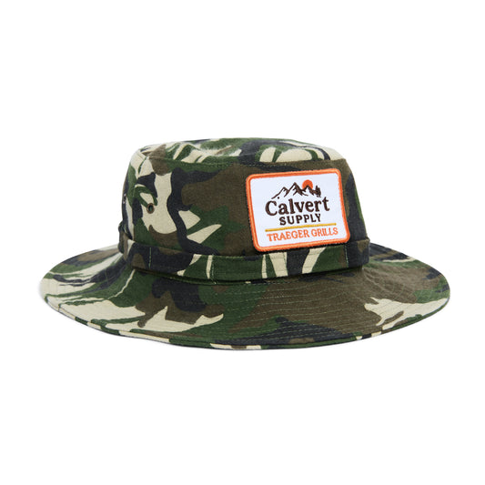Camouflage bucket hat with a Calvert Supply logo on a white background