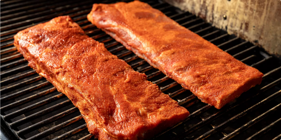 Two pieces of meat cooking on a traeger grill